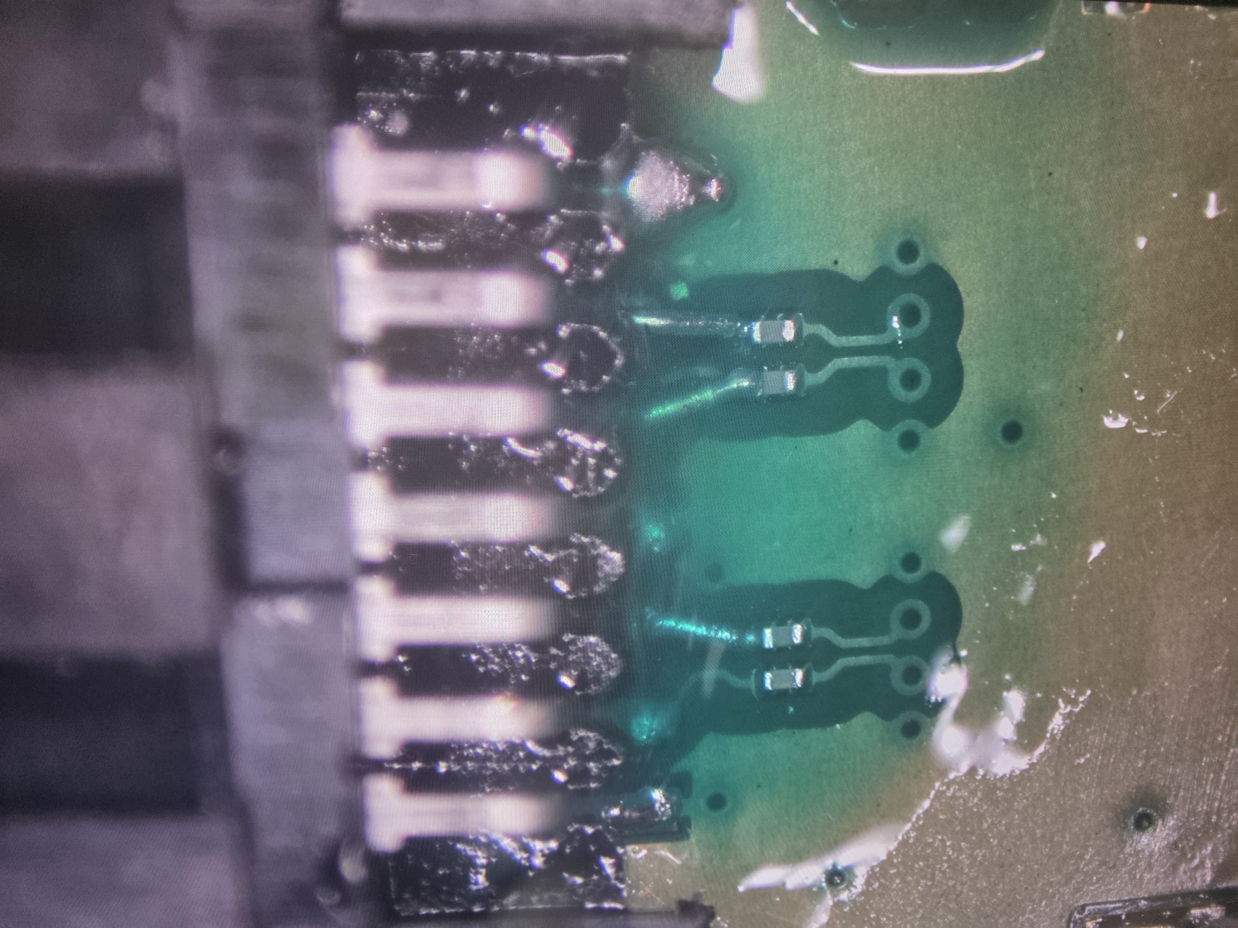 Laptop charging connector repair work under microscope